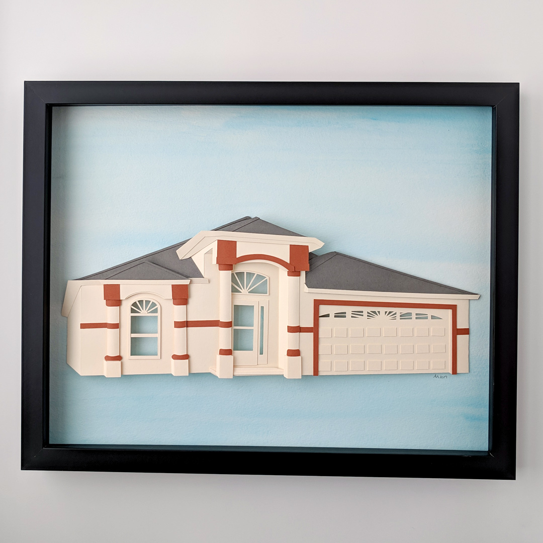 a paper model of a house in a frame