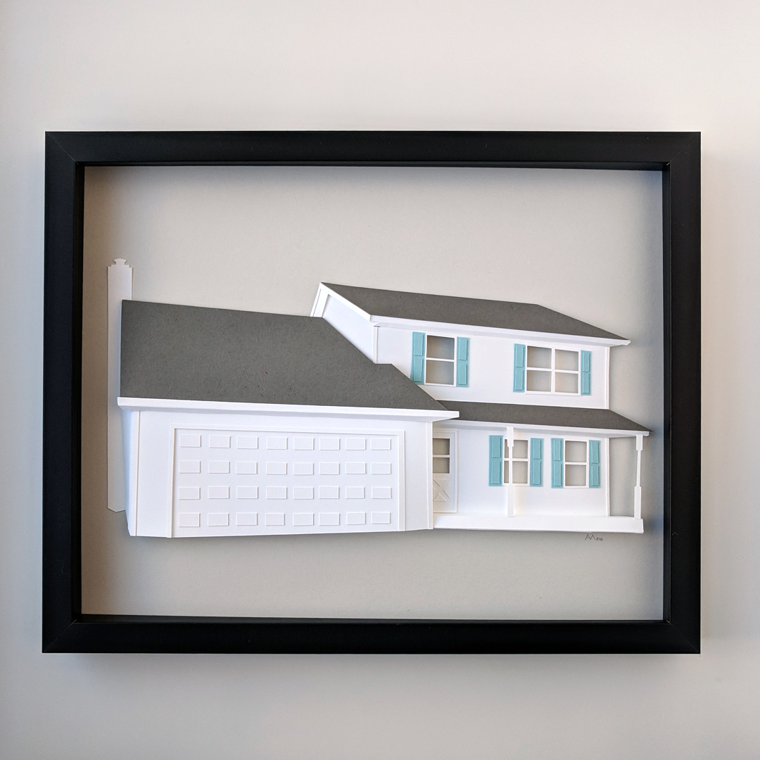 a paper model of a house in a frame