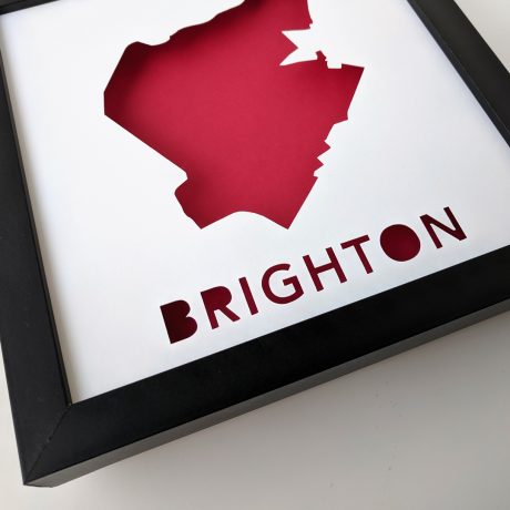 a cut-out of a map of Brighton, MA with a red background