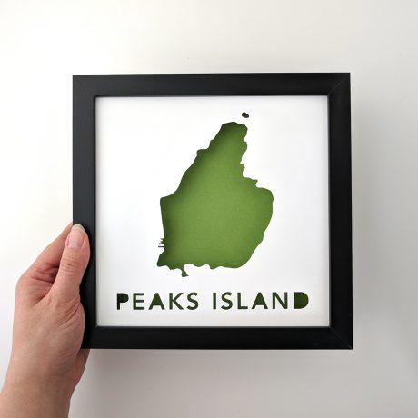 Framed map of Peaks Island with a green background, held in hand