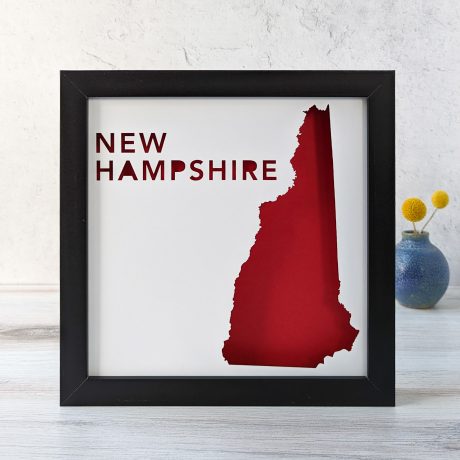 a black frame with a red map of new hampshire
