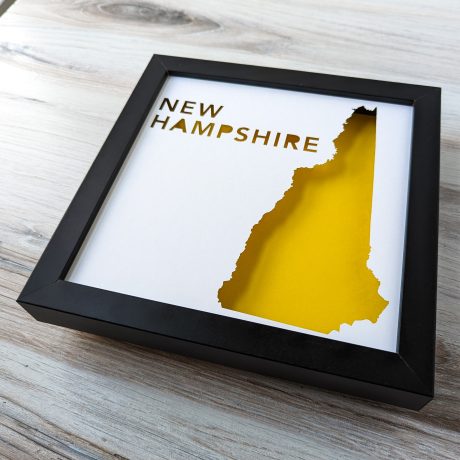 a black frame with a yellow map of new hampshire in it
