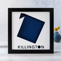 A map of Killington, Vermont cut out of white paper in a black frame with a dark blue background