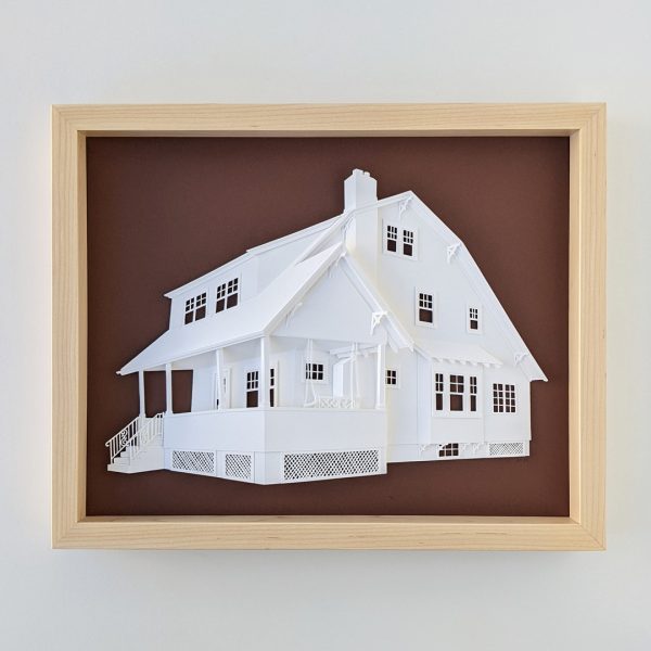 A portrait of a house with a large front porch and porch swing on a brown background in a light maple wood frame