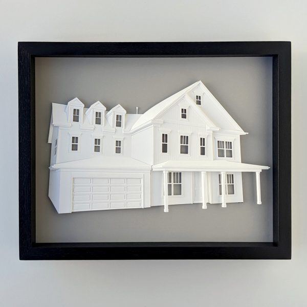 A sculptural paper portrait of a large modern house with three dormer windows over the garage