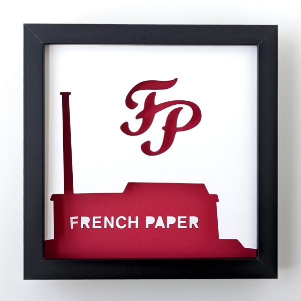 a paper cut out of a red factory building with the word French Paper on it and the French Paper Company logo above