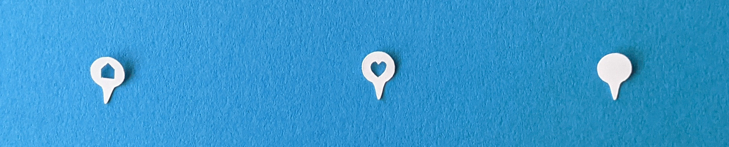 three white paper map marker pins on a blue background