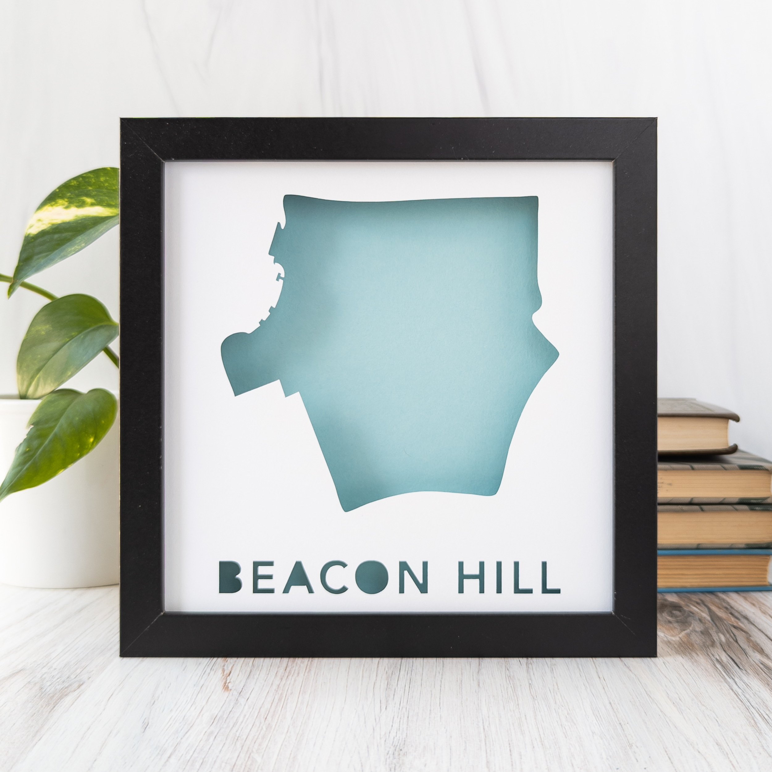 a framed light blue map of the Boston, MA neighborhood of Beacon Hill