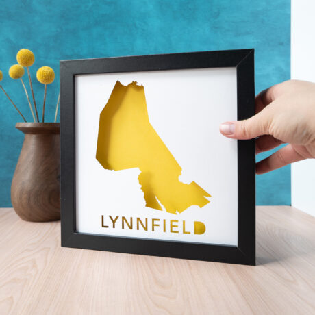 a person holding a framed print with the word lynnfield in yellow