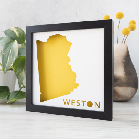 a black frame with a yellow and white map of Weston, MA