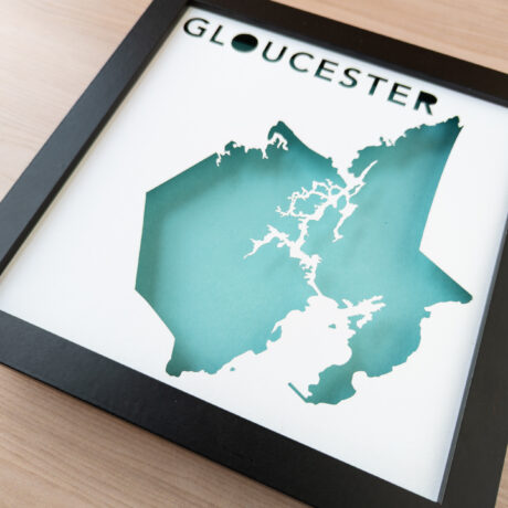 Angled view of a framed blue and white map of Gloucester, MA