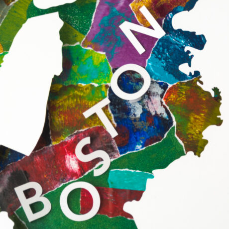 A closer view of the word "Boston" made of paper cut-out letters in the middle of the cut-out map of the city