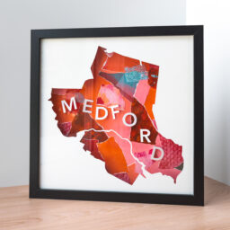 A framed map of Medford, MA cut out of white paper to reveal a pink and red textured collage with the word "Medford" spelled out of 3D paper letters