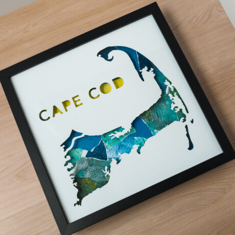 A square framed map of Cape Cod laying on a table