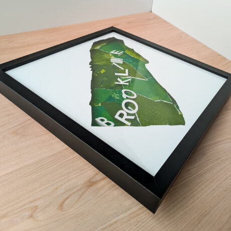 A photo of a green collaged map of Brookline, MA from an angle to the side so that the 3D letters can be seen clearly.