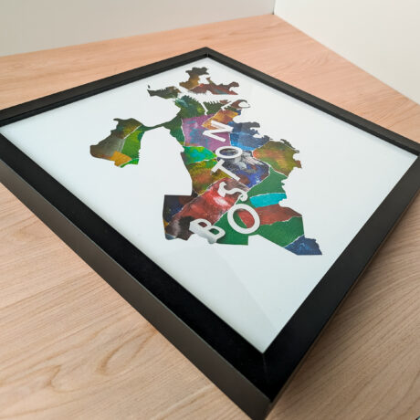 A photo of a multi-colored collaged map of Boston, MA from an angle to the side so that the 3D letters can be seen clearly.